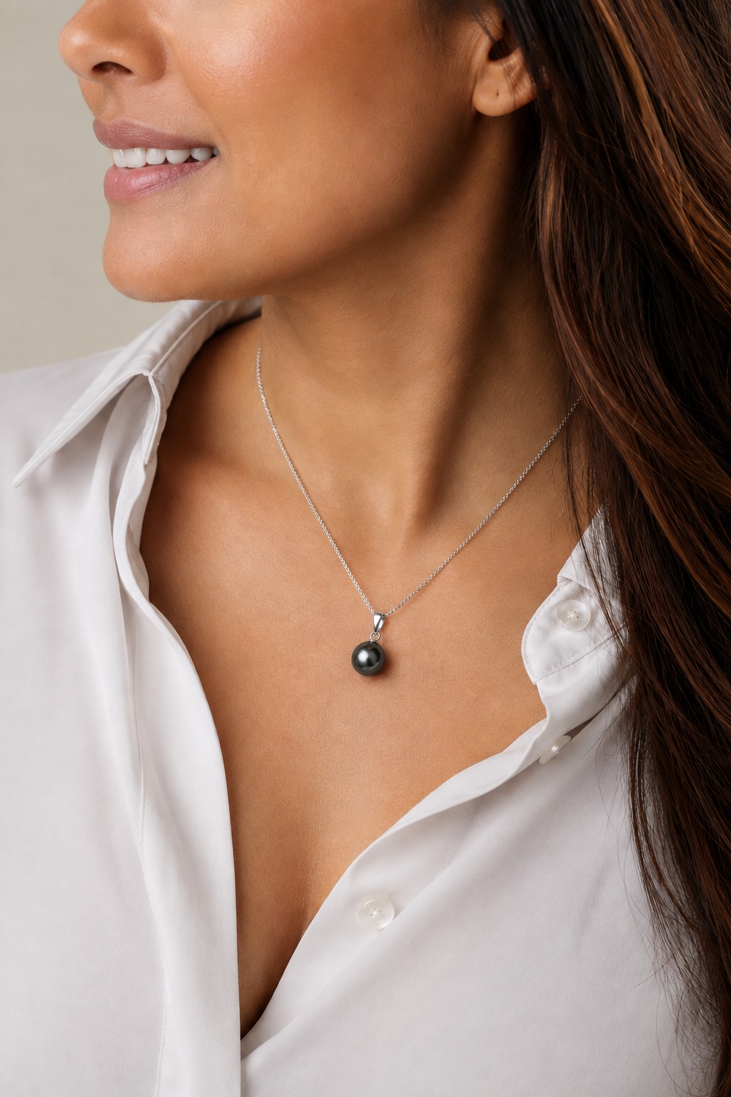 Model trägt den Sydney-Anhänger mit tahitischer Südseeperle, mit einer schwarzen runden Zuchtperle an einer zarten Kette aus Sterlingsilber.